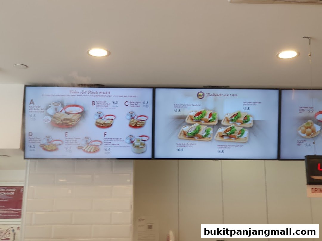Digital menu boards displaying set meals and toastwiches at Ya Kun Kaya Toast.
