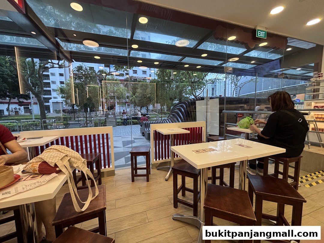 Interior view of Ya Kun Kaya Toast with customers seated at tables, looking out at the street.