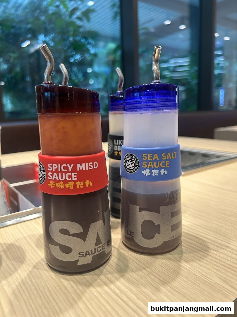 Close-up of two sauce bottles, Spicy Miso and Sea Salt, at Yakiniku Like.