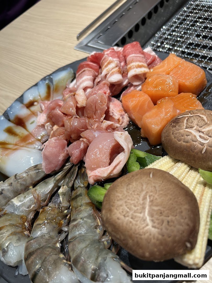 A platter of raw meats, seafood, and vegetables for grilling.