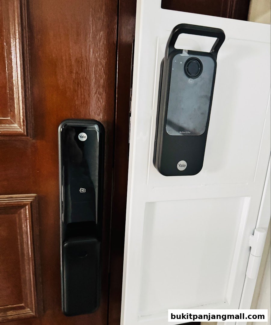 Two Yale smart locks are displayed on a wooden door and a white frame.