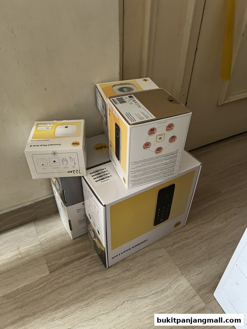 Several Yale smart home product boxes are stacked in a corner.