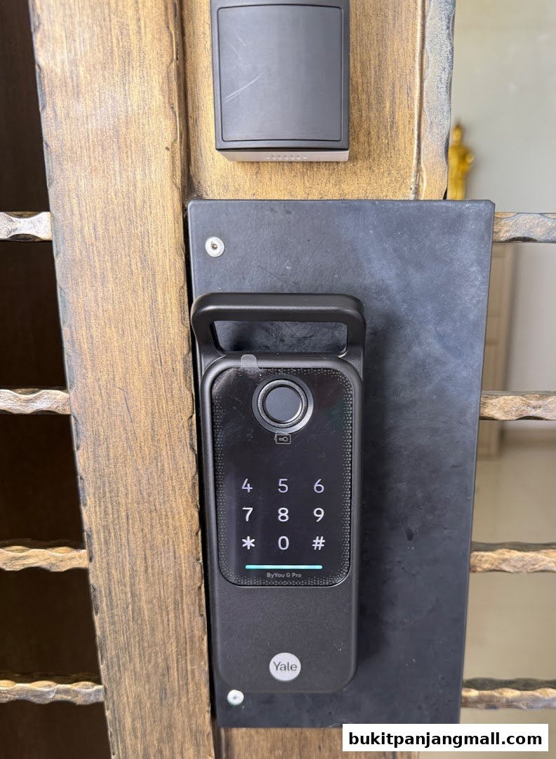 Close-up of a Yale smart lock with a keypad and fingerprint scanner on a wooden door.