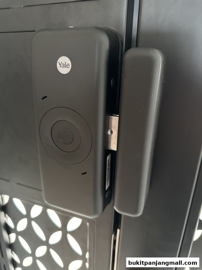 Close-up of a black Yale smart lock installed on a gate.