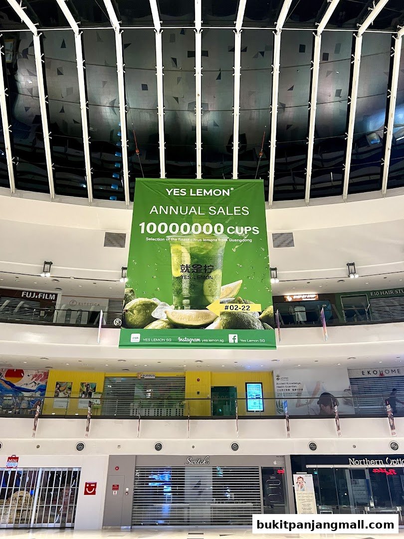 A banner for YES LEMON advertising annual sales of 10,000,000 cups hangs in a mall.