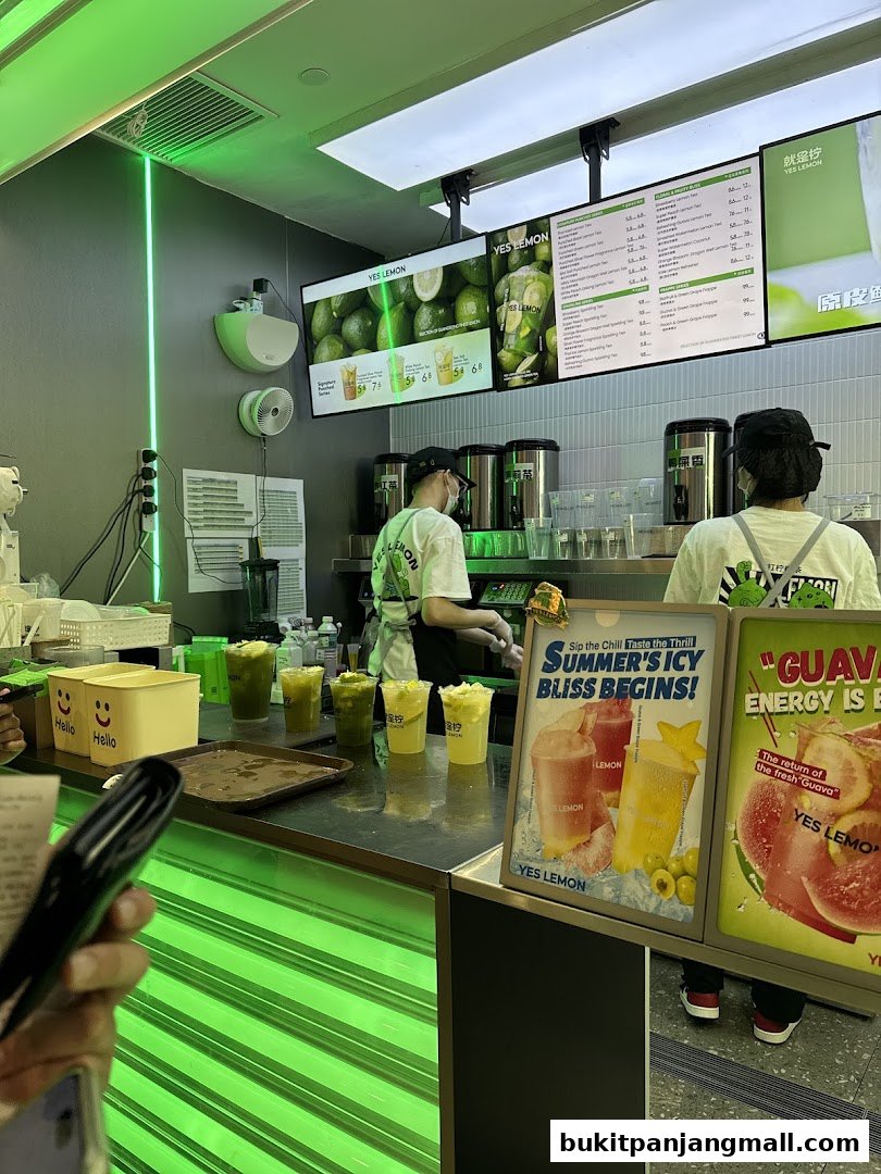 A bright and modern beverage shop counter with staff preparing drinks and a menu displayed.