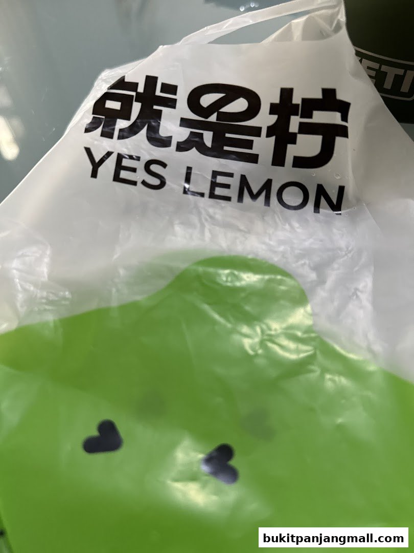 A white plastic bag with the shop name 'YES LEMON' and a green cartoon character.