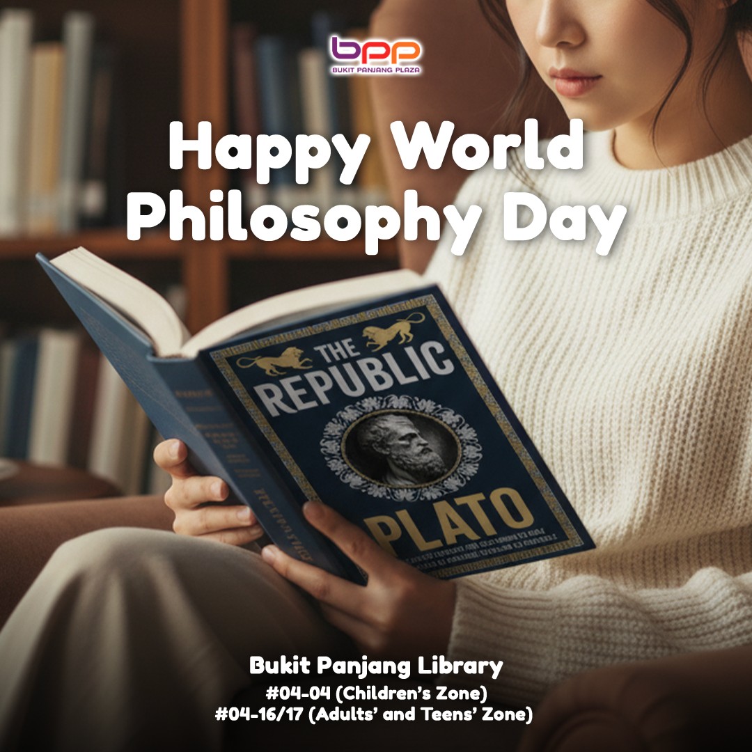 A person engrossed in a book, surrounded by towering shelves of literature at a library.